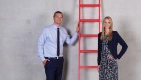 Ein Mann und eine Frau stehen bei einer roten Leiter