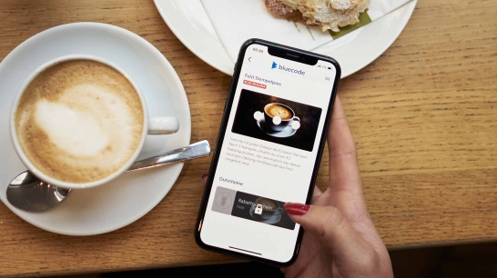 Kaffeetasse, Snack und Handy mit geöffneter Bluecode App