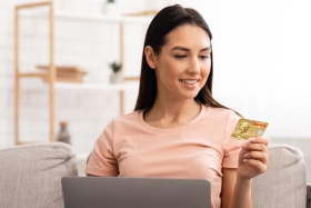 Lächelnde Frau schaut auf ihre Oberbank Debitkarte