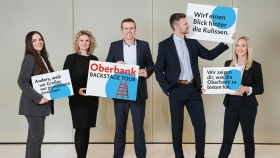 Fünf Oberbank Mitarbeiter stehen nebeneinander und halten Schilder in den Händen