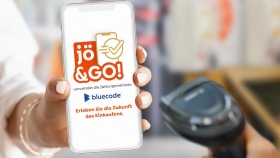 Frau zeigt Handydisplay mit geöffneter jö&GO!-App