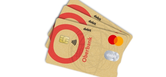 Lächelnde Frau schaut auf ihre Oberbank Debitkarte