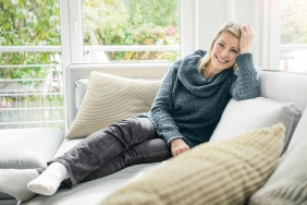 Lächelnde Frau liegt auf Couch