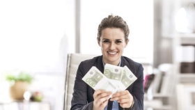 Lächelnde Frau mit Geldscheinen in Händen
