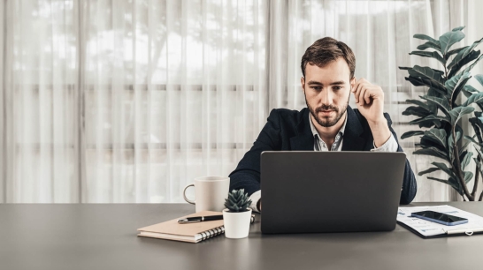 Mann sitzt vor Laptop