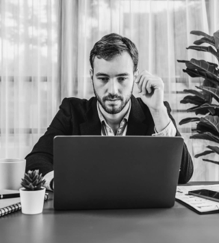Mann sitzt vor Laptop