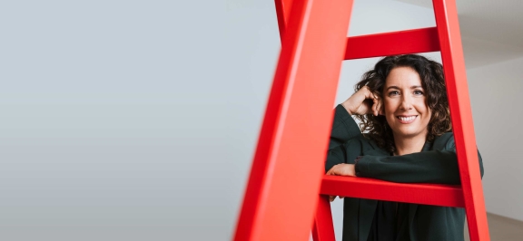 Oberbank Mitarbeiterin schaut durch rote Leiter