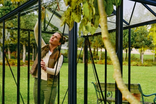Eine Frau baut ein Glashaus zusammen