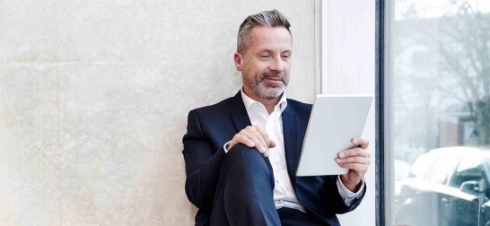 Mann öffnet Oberbank Kundenportal business auf einem Tablet.