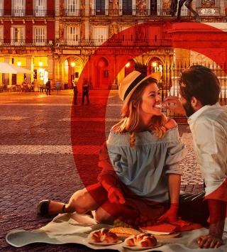 Junges Paar beim Picknick vor dem Königspalast in Madrid