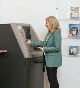 Dame bedient Bankomat mit Karte