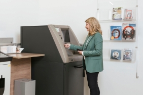 Dame bedient Bankomat mit Karte