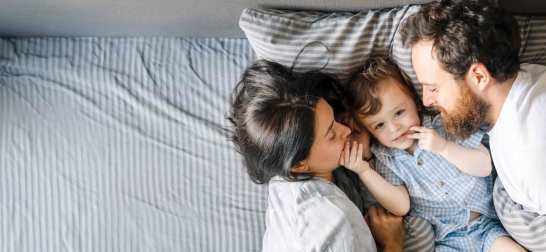Oberbank Wohnbaufinanzierung, Familie kuschelt gemeinsam in Bett