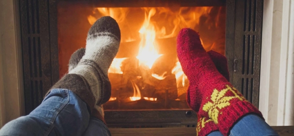 Zwei Personen sitzen vor Kamin
