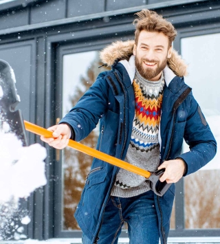 Mann beim Schneeschaufeln