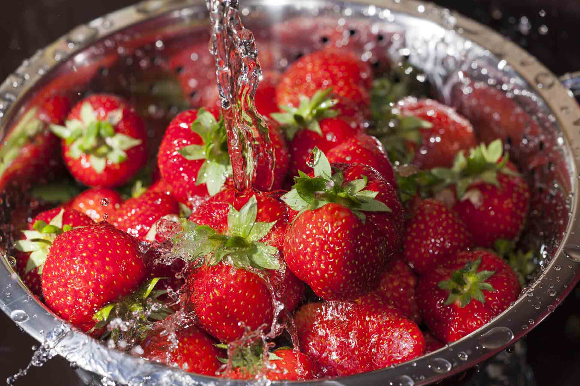 Erdbeeren werden mit einem Sieb gewaschen