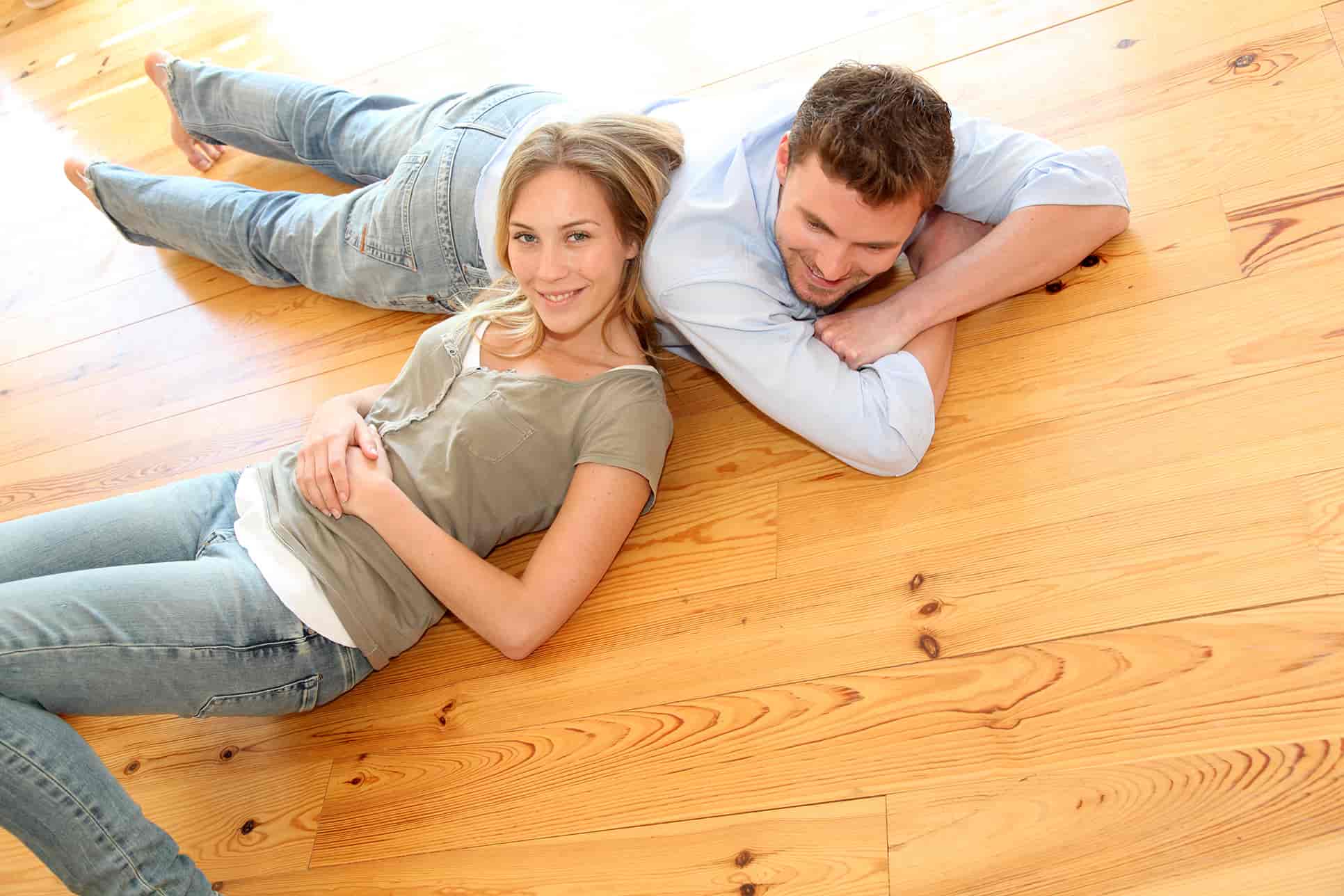 Paar liegt am Holzboden