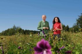 Mann und Frau stehen in grüner Blumenwiese