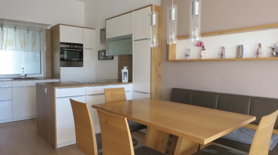Ausgestattete Küche mit Esstisch und Stühlen aus Holz